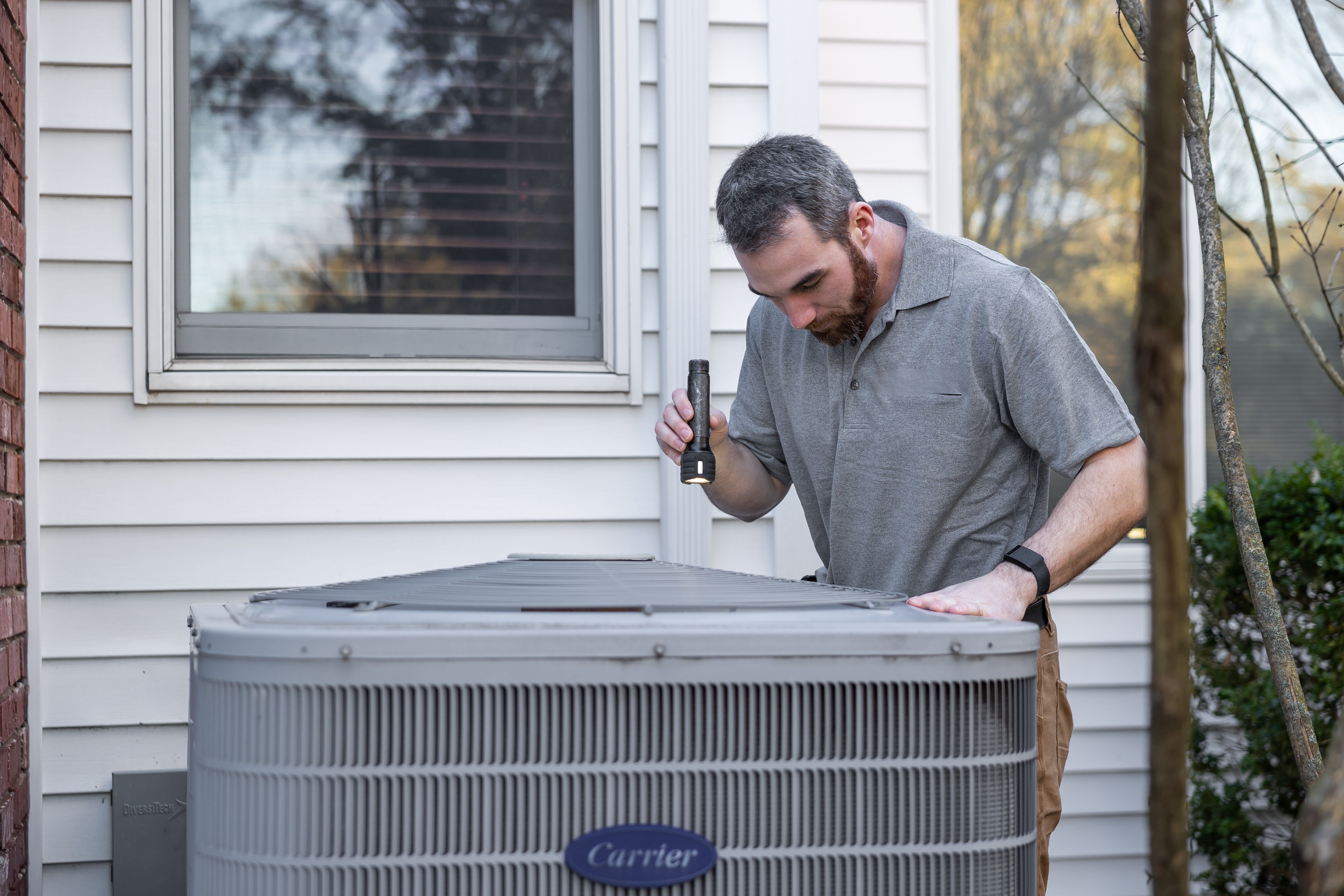 HVAC technician servicing a residential air conditioning unit